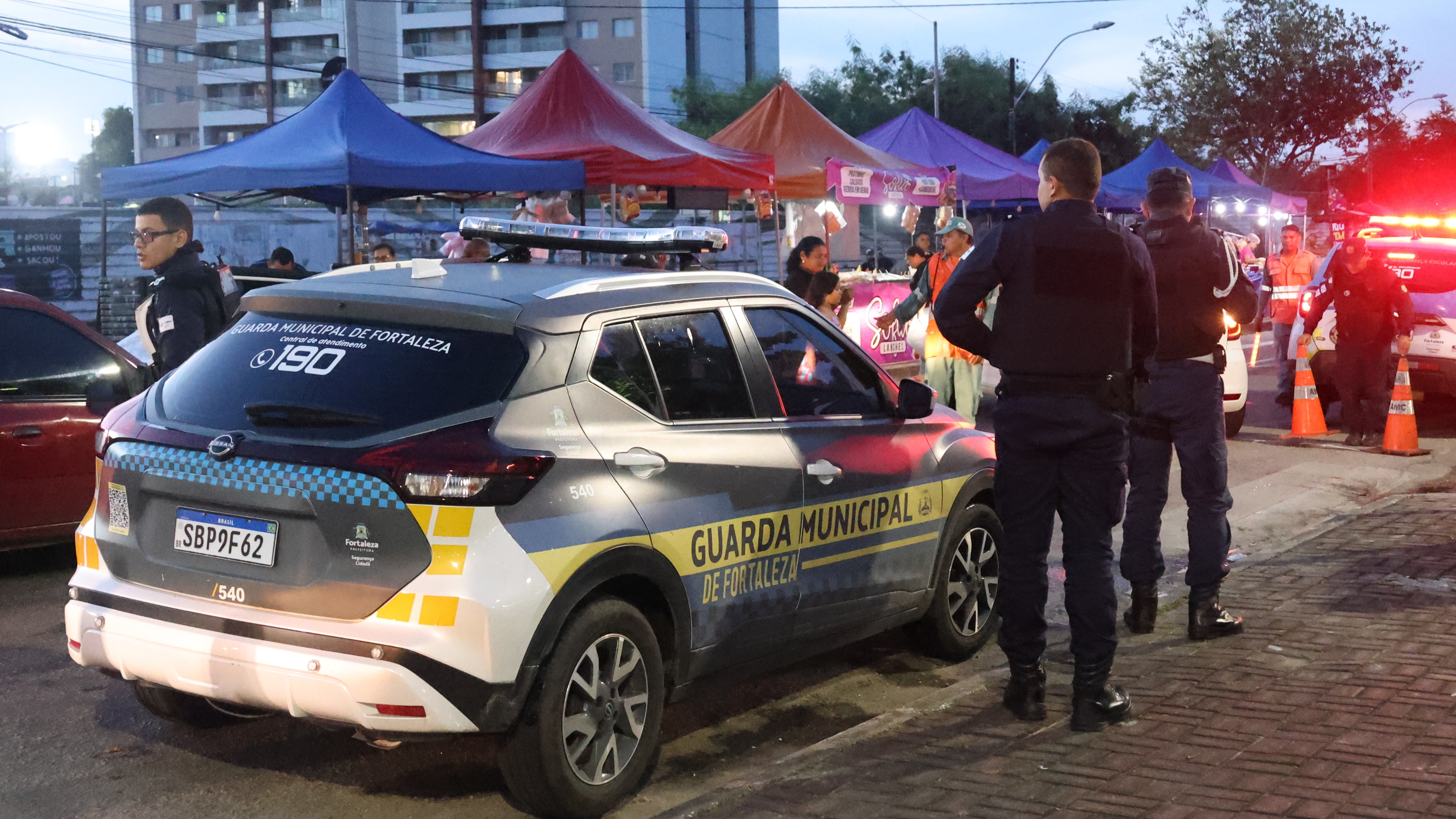 guardas municipais ao lado de uma viatura em uma via